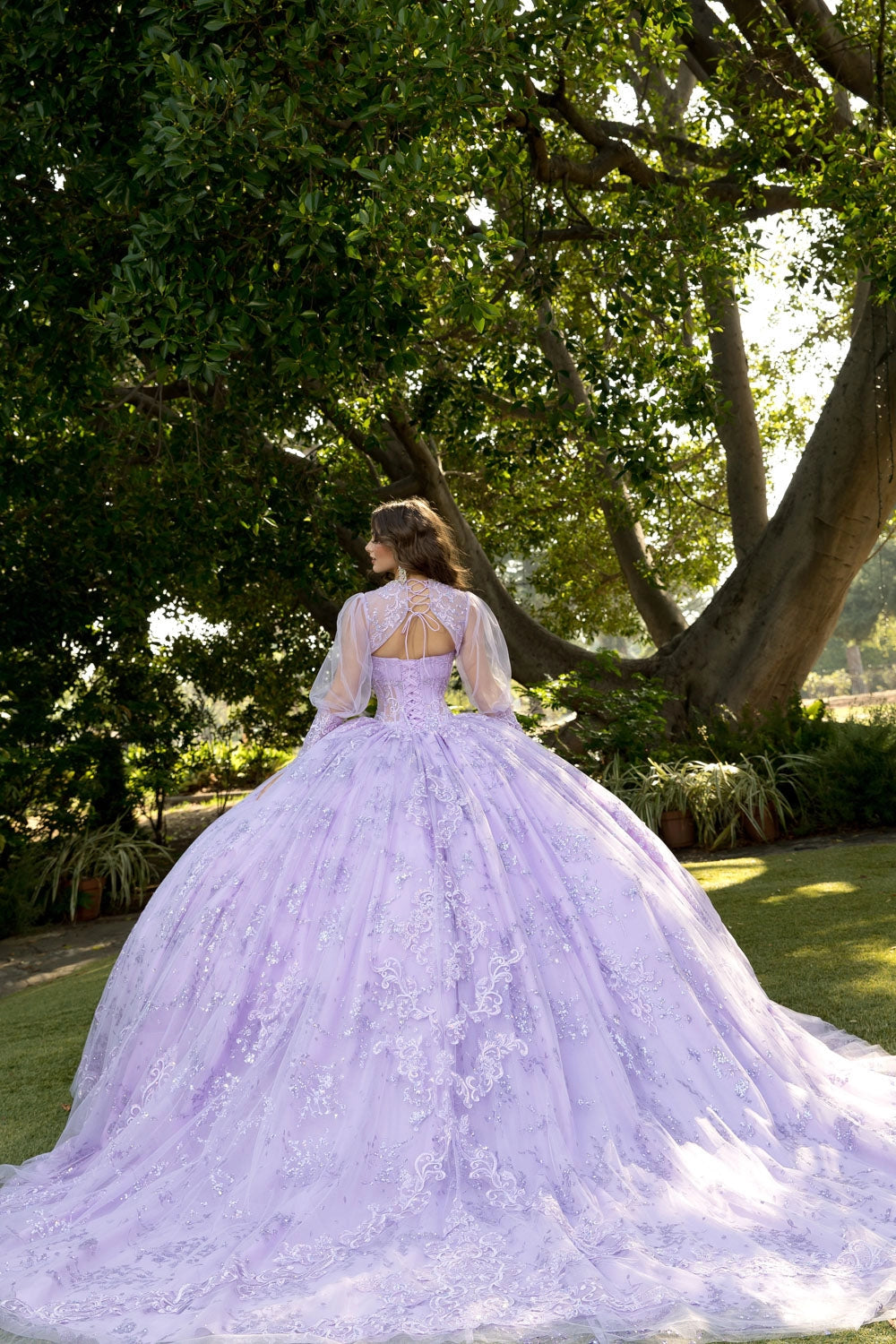 Rear detail of Vedress lavender quinceañera dress with corset lacing, styled with a sheer puff-sleeve bolero featuring upper-back ties.